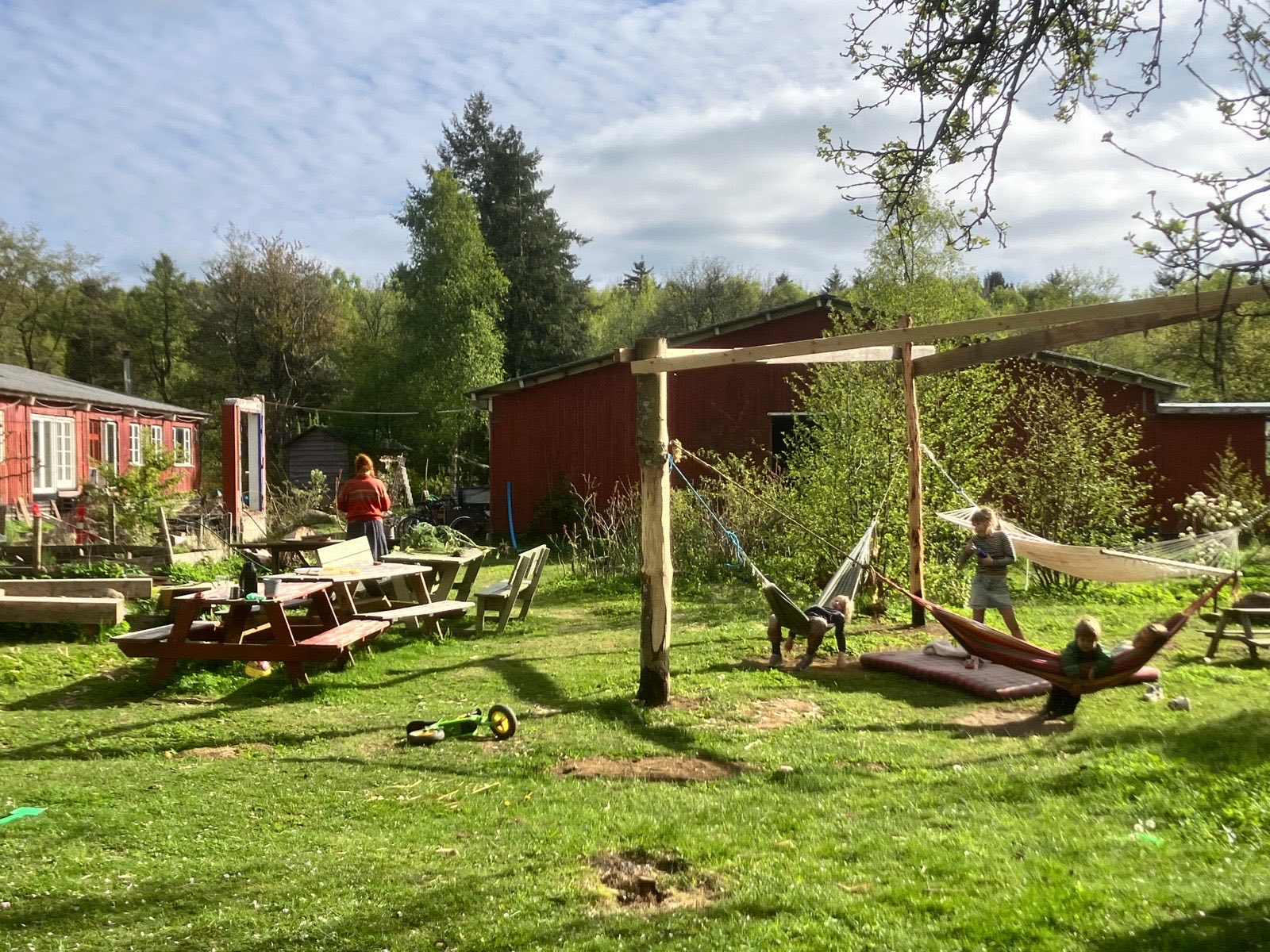 Børn i hængekøjer på fællesarealet mellem de røde huse