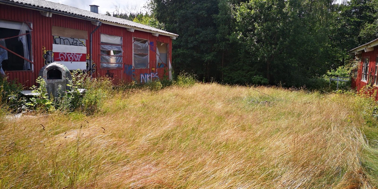 De gamle røde barakker, som de så ud ved overtagelsen — tomme og overmalede